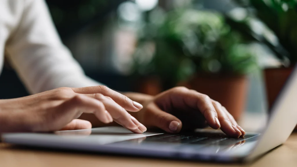 Female hands writing copy on her laptop