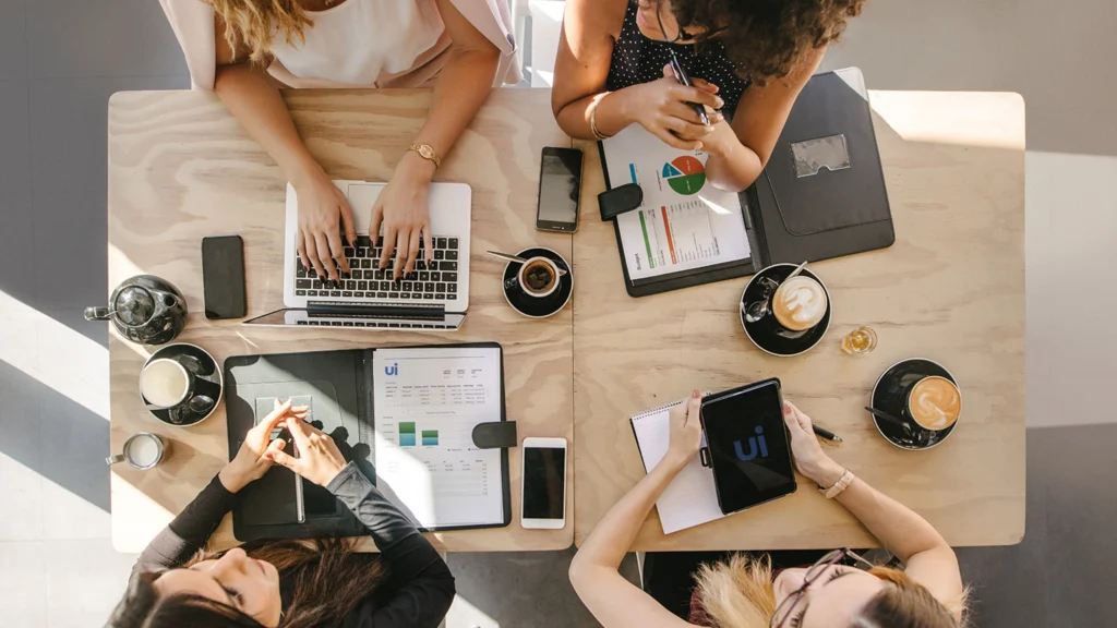 Group of Urge Interactive employees sitting around table planning a clients marketing strategy