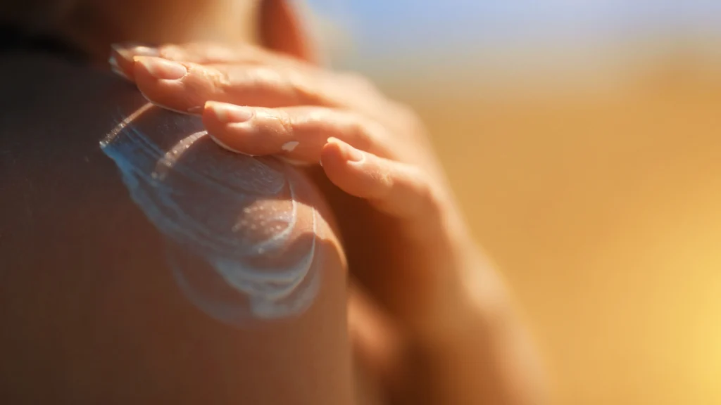 Woman rubbing sunscreen SPF on her shoulders during 5 Ways to Market Your Derm Practice During Melanoma Awareness Month